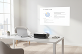 WiFi home projector connected to a laptop via HDMI projecting onto a wall in a home office
